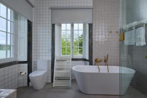a bathroom with a tub and a toilet and a sink at Casa Dos Barcos Furnas in Furnas +22 photos