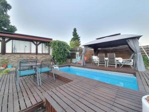 a wooden deck with a swimming pool and an umbrella at Apartment Casa Sarajevo in Sarajevo