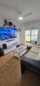 a living room with a large flat screen tv at Terraza al mar in Salobreña