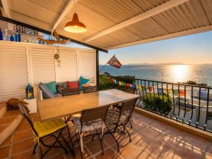 a patio with a table and chairs on a balcony at 'Cardamom House', Enchanting Vacation Home 2 min from the Beach, Sleeps 5 in Gordonʼs Bay