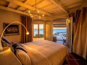 a bedroom with a bed with a view of the ocean at 'Cardamom House', Enchanting Vacation Home 2 min from the Beach, Sleeps 5 in Gordonʼs Bay