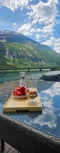 a plate of fruit on a table with a view at Modern lakefront apt with view - EV plug in Stryn