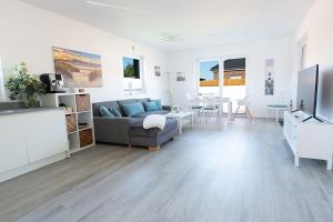 a living room with a couch and a table at Sonne & Sand Strandnahes Ferienhaus mit Whirlpool, Sauna & Wallbox in Büsum