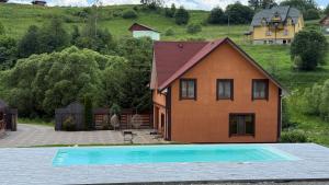 a house with a swimming pool in front of it at U Troh Brativ in Plavie