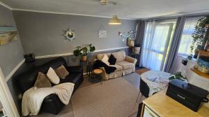 a living room with a couch and a table at Netty's Retreat in Hemsby