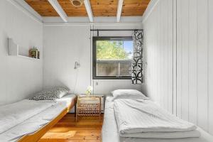 a bedroom with two beds and a window at 1007-N-Hundested-Humlehaven-5 in Hundested