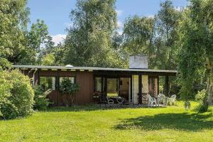 a cabin with a table and chairs in a yard at 1007-N-Hundested-Humlehaven-5 in Hundested