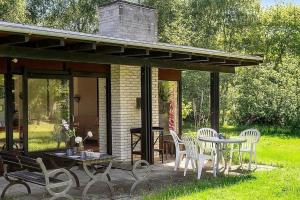 a patio with white chairs and a table and a table and chairs at 1007-N-Hundested-Humlehaven-5 in Hundested +7 photos