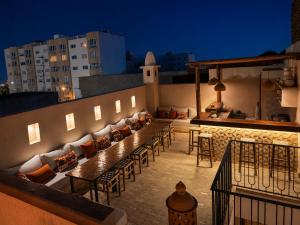 a rooftop patio with couches and tables on a building at Riad Timoun in Agadir