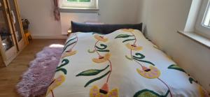 a bed with a comforter on it in a room at Cozy city appartement in Forchheim