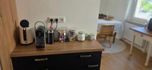 a wooden counter top with cups and utensils on it at Cozy city appartement in Forchheim