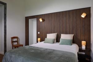a bedroom with a large bed with two green pillows at Casa Dos Barcos Furnas in Furnas