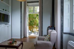 a living room with a chair and a table at Casa Dos Barcos Furnas in Furnas