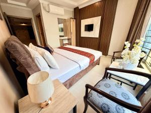 a bedroom with a bed and a table and a chair at Hotel Islamabad Premiere Inn in Islamabad