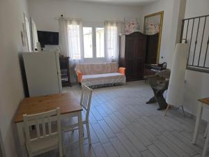 a living room with a table and a couch at camera con terrazza vicino al mare e pineta in Follonica