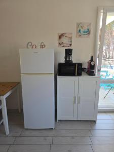 a kitchen with a white refrigerator and a table at camera con terrazza vicino al mare e pineta in Follonica