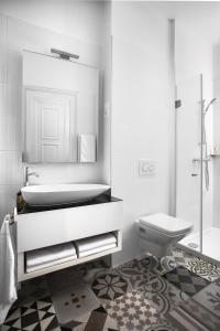 een badkamer met een wastafel, een toilet en een spiegel bij Brill Budapest Apartments 3 in Boedapest