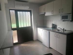 a small kitchen with a door and a sink at Serra e Mar in Alcaria
