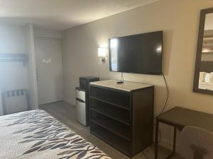 a hotel room with a bed and a flat screen tv at Red Roof Inn Media, PA in Media
