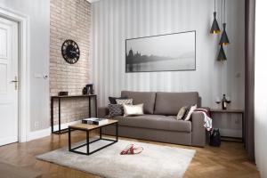 ein Wohnzimmer mit einem Sofa und einem Tisch in der Unterkunft Brill Budapest Apartments 3 in Budapest