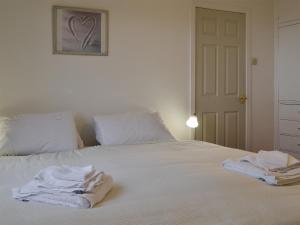 a white bed with towels sitting on top of it at Ruach in Gardenstown