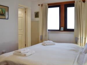 a bedroom with two towels on a white bed at Ruach in Gardenstown