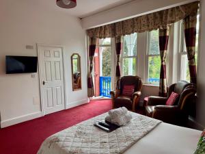a hotel room with a bed and two chairs at Hotel Hudson in Torquay