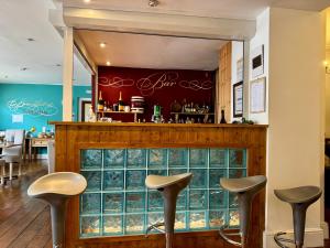 a bar with three stools in a restaurant at Hotel Hudson in Torquay