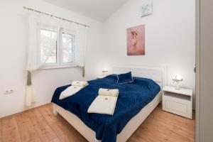 a white bedroom with a blue bed and a window at Villa Dea in Vučevica +23 photos
