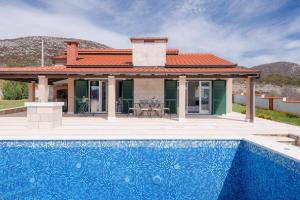 a house with a swimming pool in front of a house at Villa Dea in Vučevica