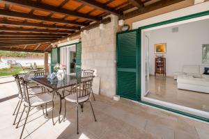 a dining room with a table and chairs on a patio at Villa Dea in Vučevica