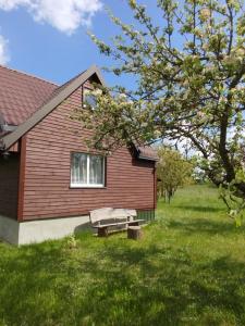 a red house with a bench in front of it at Sielanka na wzgórzu in Czostków