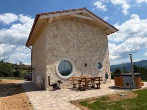 a large stone building with a picnic table in front of it at Farma HUGÁNIKOVO - families, pets & spa relaxation in Brezno