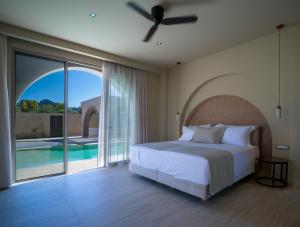 a bedroom with a bed and a sliding glass door at The Landmark Villas & Spa in Kolymbia +257 photos
