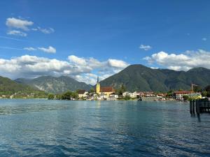 a large body of water with a town and mountains at Seehäusl mit Badeplatz in Tegernsee