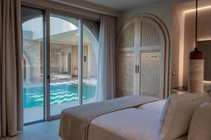 a bedroom with a bed and a view of a pool at The Landmark Villas & Spa in Kolymbia