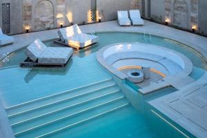 a swimming pool with two chairs and a table at The Landmark Villas & Spa in Kolymbia