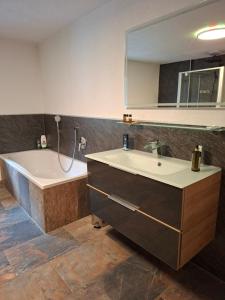 a bathroom with a tub and a sink and a bath tub at Gästehaus Hammerle Holzgau in Holzgau