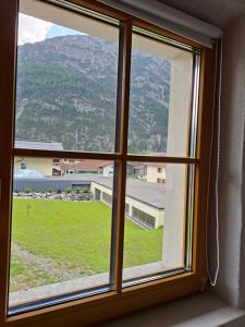 a window with a view of a mountain at Gästehaus Hammerle Holzgau in Holzgau +24 photos