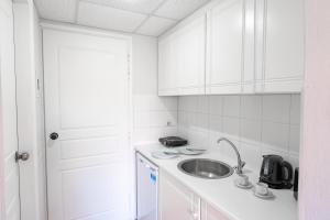 a white kitchen with a sink and a counter at Hotel Asimina Laganas in Laganas