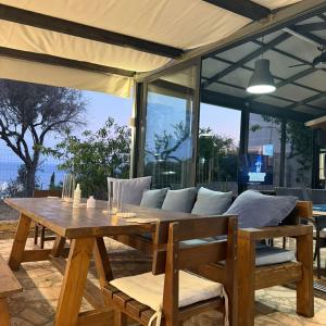 a wooden table with pillows on a patio at La Maroja View Hotel in Dhërmi
