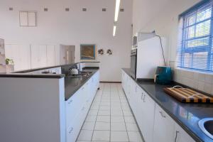 a kitchen with white cabinets and a black counter top at Kuda Breeze in St Lucia