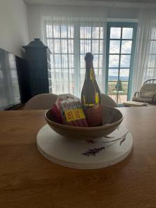 a bottle of alcohol in a bowl on a table at Farma HUGÁNIKOVO - families, pets & spa relaxation in Brezno