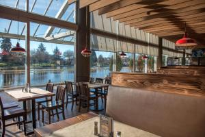 a restaurant with tables and chairs and a view of the water at Coast Chilliwack Hotel by APA in Chilliwack