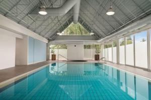 a swimming pool with blue tiles on the floor and windows at Coast Chilliwack Hotel by APA in Chilliwack
