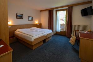 a hotel room with a bed and a window at Bormiohomes - Case SteLu in Bormio