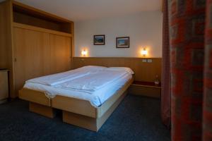 a bed in a bedroom with two lights on the wall at Bormiohomes - Case SteLu in Bormio