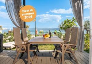a table and chairs on a deck with a view of the ocean at Camping Almissa in Omiš +34 photos