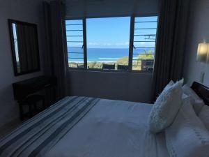 a bedroom with a bed with a view of the ocean at #9 Illovo Views in Kingsborough +21 photos