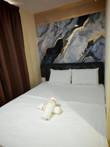 a bed with a toy on top of it at 28 Gred Hotel in Bukit Mertajam